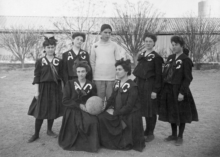 Five Female Aggie athletes posing with coach in uniforms